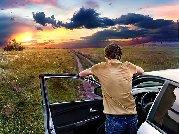 istock guy is standing near car and looking at the sunset 183442879