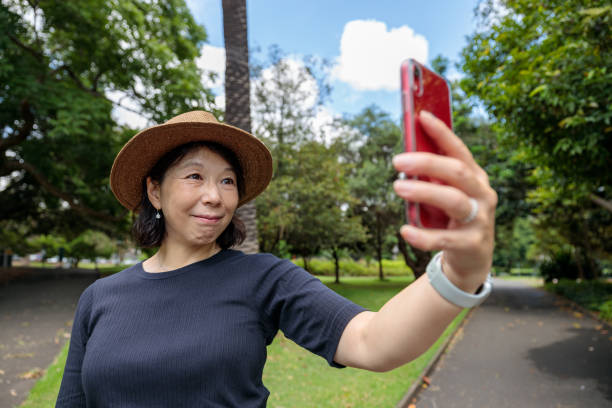 istock Smiling woman in a park taking a selfie. 1834429426