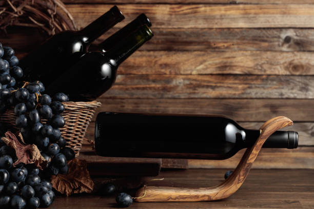 istock Red wine and blue grapes on an old wooden table. 1834429938