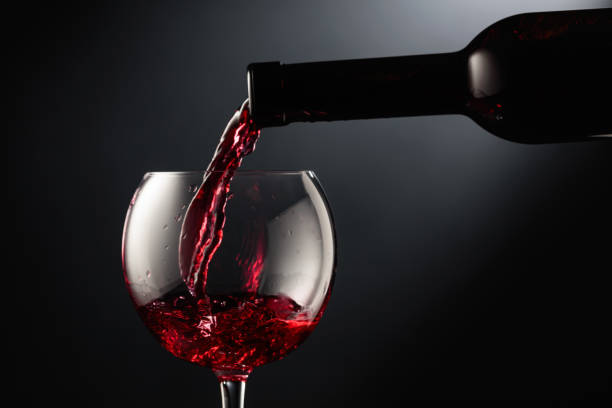 istock Pouring red wine into a wine glass. 1834429965