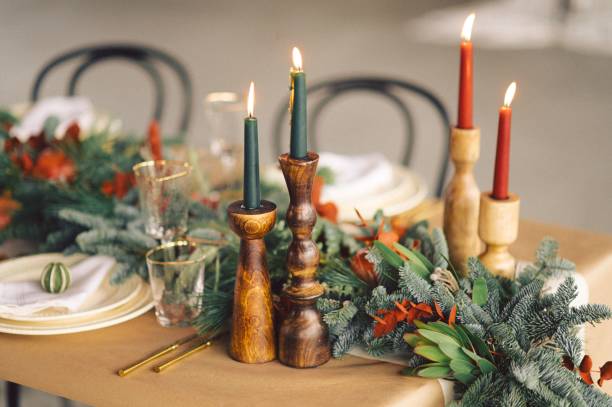 istock Table adorned with candles, green foliage and decorative tableware ideal for Christmas celebrations 1834451577