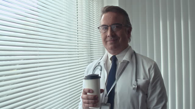 Portrait of General Practitioner Drinking Coffee and Looking at Camera