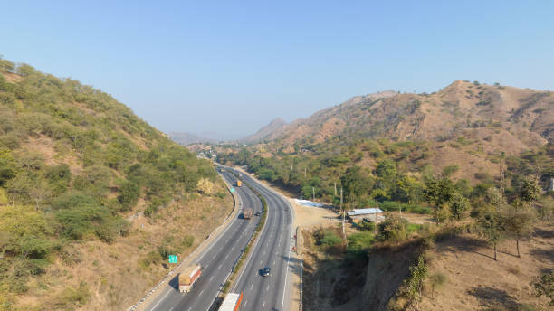 istock Aerial view of a expressway passing through low rise mountains 1834493445