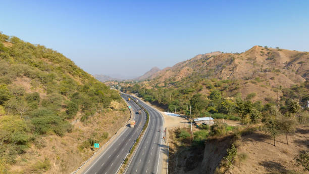 istock Aerial view of a expressway passing through low rise mountains 1834493460