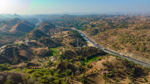 istock Aerial view of a expressway passing through low rise mountains 1834493462