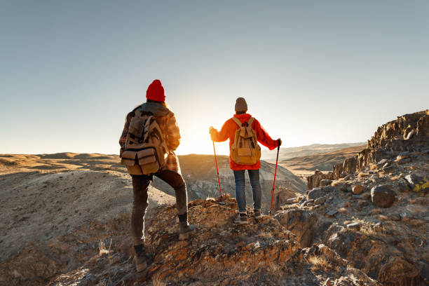 istock Two hikers are standing at sunset cliff 1834506346