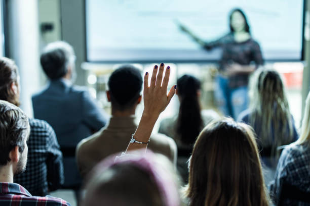 istock Back view of creative woman asking a question on education event in the office. 1834523650