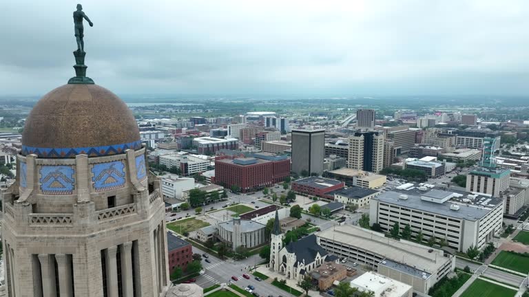 Nebraska state capitol building with Lincoln skyline. Aerial establishing shot.