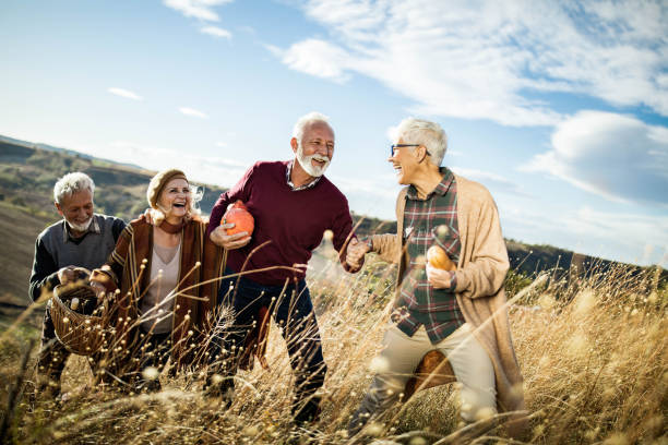 istock Happy mature couples going on a picnic in autumn day. 1834544890