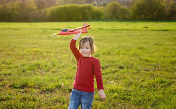 istock A little girl is holding a toy airplane while playing in a meadow 1834544906