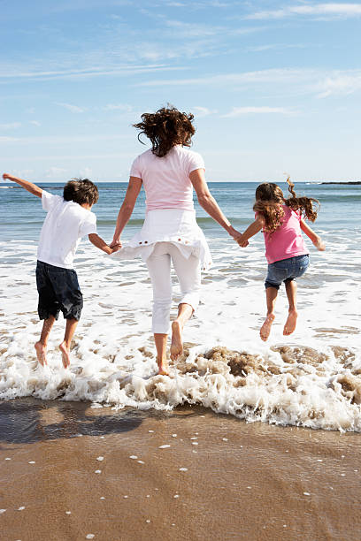 istock Mother and children having fun on the beach 183455003