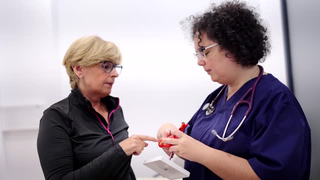 Cardiologist using a heart model to explain problems to patient