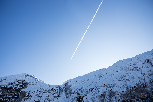 Aircraft Flying Over European Alps In Late Winter Afternoon Blue Sky