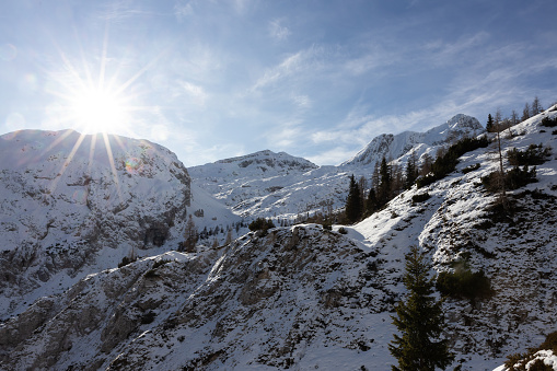 White winter mountains with snow and bright shining sun and sunrays