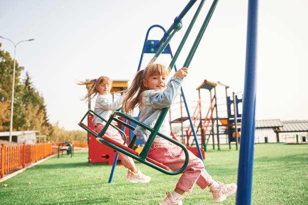 istock Enjoying swing ride. Kids are having fun on the playground 1834630072