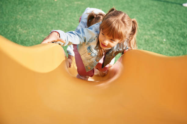 istock On a playground slide. Little girl is having fun on 1834630632