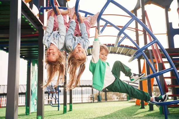 istock Hanging upside down. Kids are having fun on the playground 1834633371