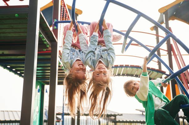 istock Hanging upside down. Kids are having fun on the playground 1834633903