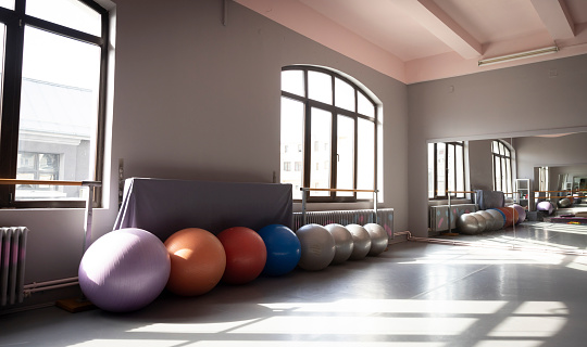 Wide angle view of a ballet room with swiss balls.