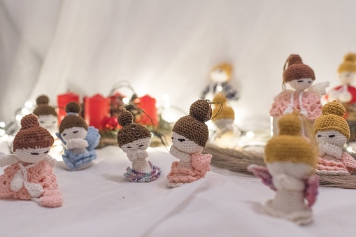 An arranged set of crocheted doll figurines placed on a white tablecloth background