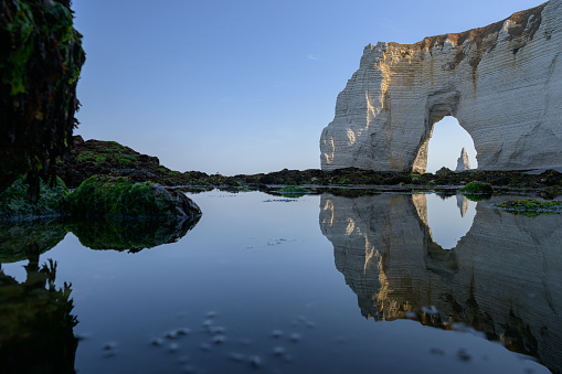 Chalk cliffs of Etretat (Normandy France) on a sunny day in summer, reflection in water