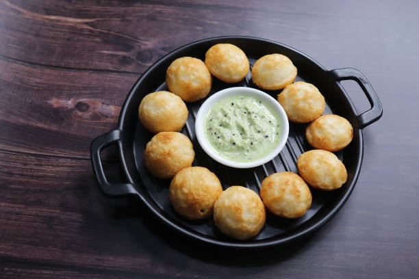istock Paniyaram are savory balls made using fermented rice and urad dal batter along with tempered onion and spices. Also known as Paddu, Ponganalu, Kuli, bugga, and appe. served with coconut chutney 1834669357