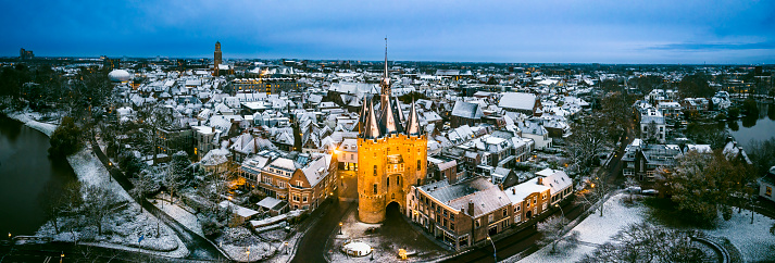 Zwolle Sassenpoort old gate during a cold winter morning with snow on the rooftops in the downtown district seen from above. The Sassenpoort was constructed in the 14th century, specifically between 1406 and 1409, and served as one of the main entrances to the fortified city of Zwolle. It was built as part of the city's defensive walls and was primarily used to control access into the city, as well as to protect its inhabitants from potential threats.

The gate's name, 