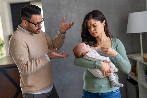 Family violence. Aggressive nervous man arguing with his wife who has postpartum depression