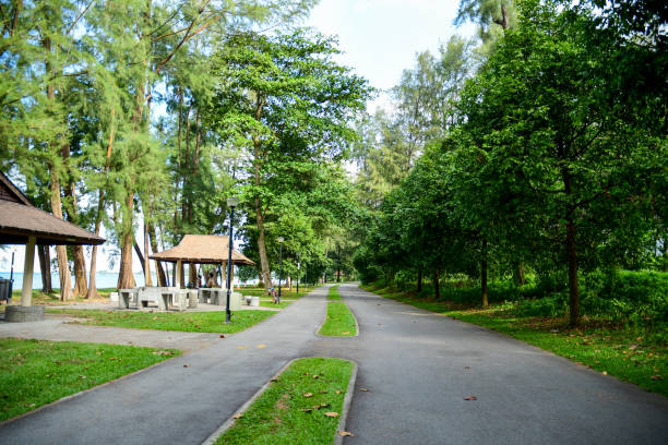 Singapore – August 19, 2022: A man and a woman taking a break from cycling at a shed at the Changi Beach Park in Singapore.