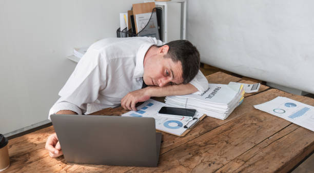 istock Unhappy young office worker feeling bored at work looking at laptop with a hopeless expression while sitting in the office. Male office worker feeling tired from monotonous work. 1834739511