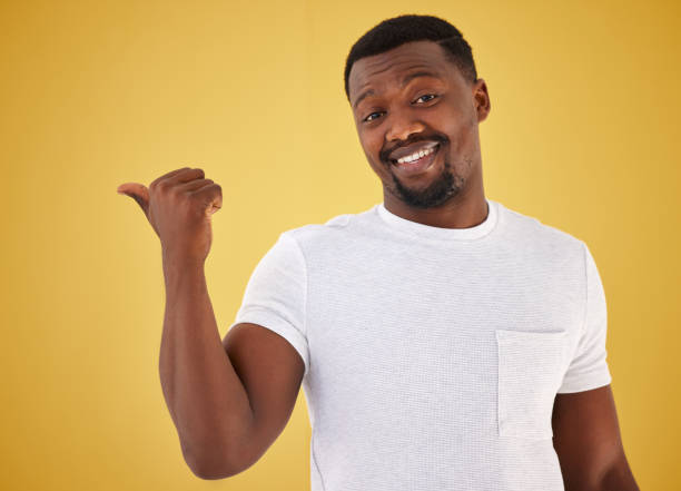 istock Man, portrait and smile or pointing in studio on yellow background, mockup space for choice information. Black person, face with hand gesture for decision show launch, promo deal or offer opinion 1834757731