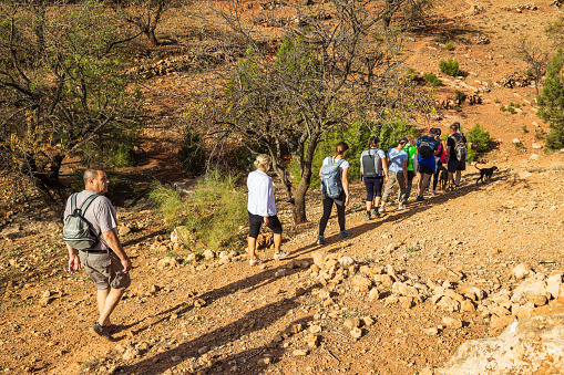 Group of tourists on hiking on trails near Ouzud town, Atlas, Morocco. All Model released.