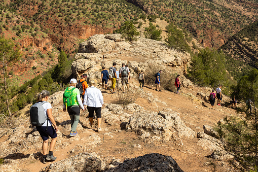 Group of tourists on hiking on trails near Ouzud town, Atlas, Morocco. All Model released.