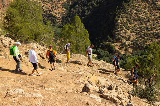 Group of tourists on hiking on trails near Ouzud town, Atlas, Morocco. All Model released.