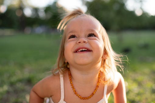 Close-up portrait of a happy little girl in the park