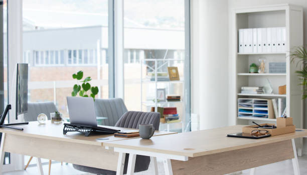 istock Clean, bright and empty home office interior organized with a computer and desk inside. Modern, contemporary and work space view of a decorated room with stylish decor and wooden furniture indoors 1834820317