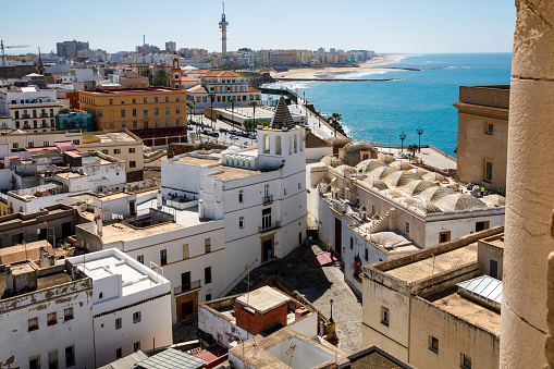 Aerial panoramic view of the old city rooftops and Cathedral de Santa Cruz in the afternoon from tower Tavira in Cadiz, Andalusia, Spain.