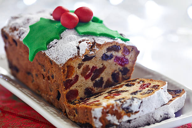 Christmas fruit cake Christmas fruit cake decorated with holly and berries fruitcake stock pictures, royalty-free photos & images