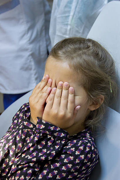 istock frightened girl at dentist's office 183483741