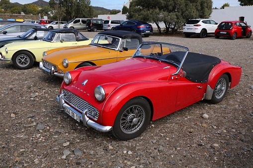 Triumph TR2 red roadster sports car parked in Spain.