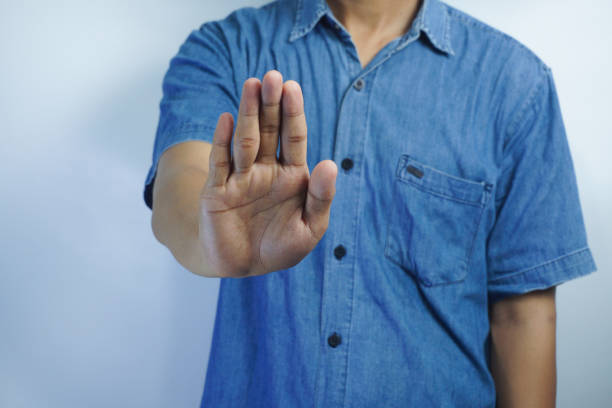 istock Young handsome man wearing t shirt over white background serious and doing stop sing with palm of the hand. 1834874179