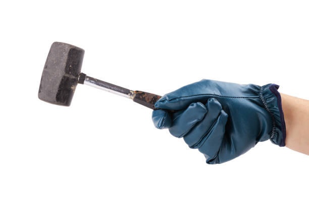 A worker's hand in a protective glove holds a hammer on a white background.