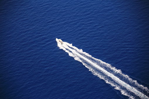 aerial view of a yacht cruising on the blue sea