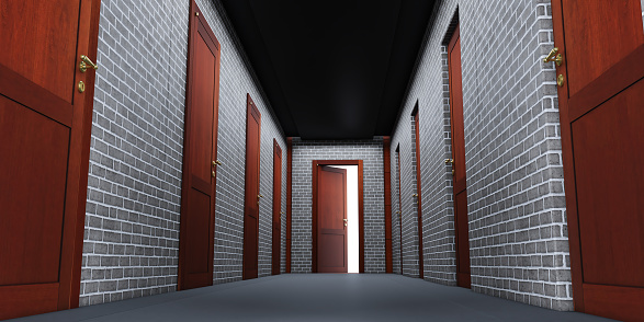 Perspective of a long modern empty office corridor with several gray doors. The floor is tiled and the lights are on.