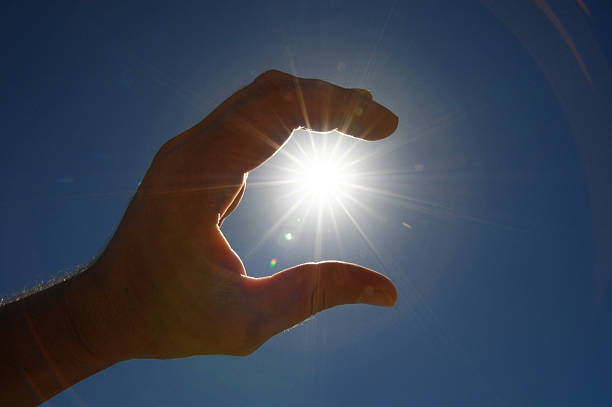 istock One Hand Catching the Sun Stars on a Blue Background 183490865