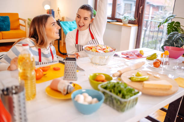 istock Girls having fun with making pizza at home 1834909799