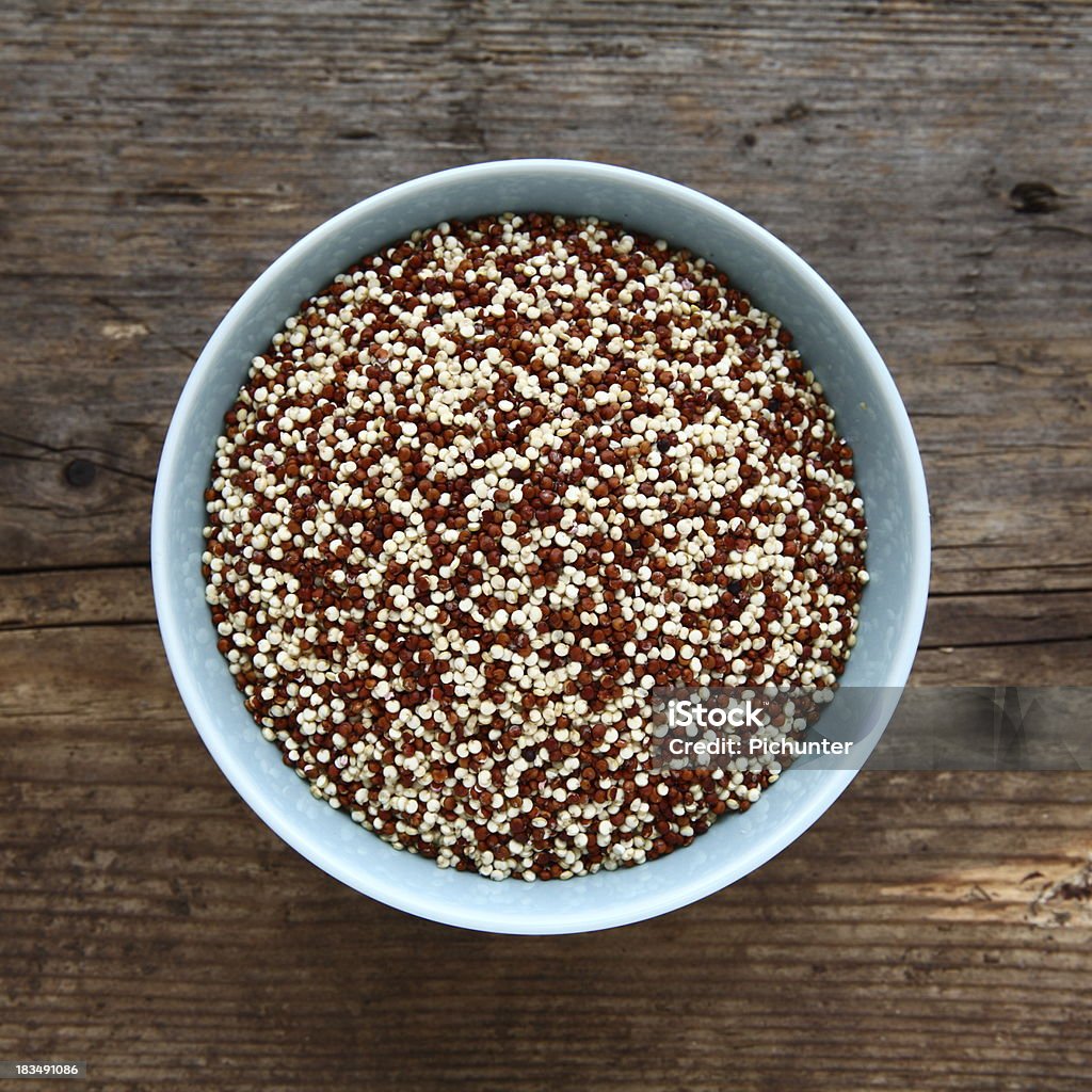 Quinoa Seeds Uncooked In A Bowl Red And White Quinoa Seeds Uncooked In A Blue Bowl On An Old Rustic Wooden Farmhouse Table Top. Quinoa Seeds Are A Wheat Grain Substitute For Those With Gluten Allergies Or A Healthy Eating Option. Blue Stock Photo