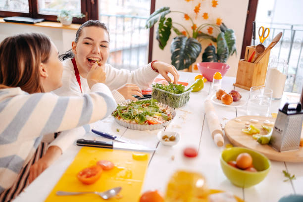 istock Girls having fun with making pizza at home 1834910911