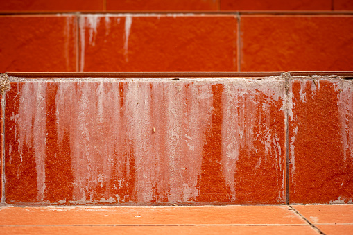 efflorescence, stain on the concrete wall white sediment formed on surfaces with component of cement, orange wall with craking leaking dirty stain