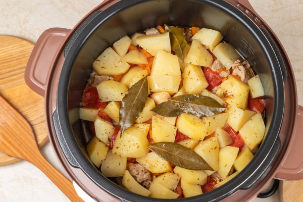 istock Modern, bright light multi cooker with just cooked stewed potatoes with meat on the kitchen table. Top view of multi cooker with just cooked dish. 1834934825